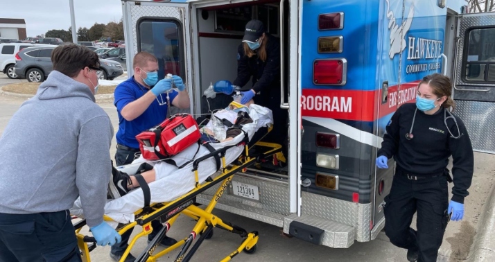 Emergency Medical Services students practice loading a patient into an ambulance