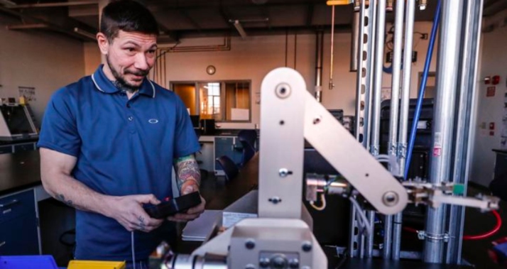 Eric Grove controls the Amatrol Pegasus training robot in the IGNITE program lab at TechWorks in Waterloo.