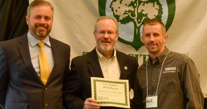 Hawkeye President Todd Holcomb accepts a certificate designating the college a 2021 Tree Campus USA location